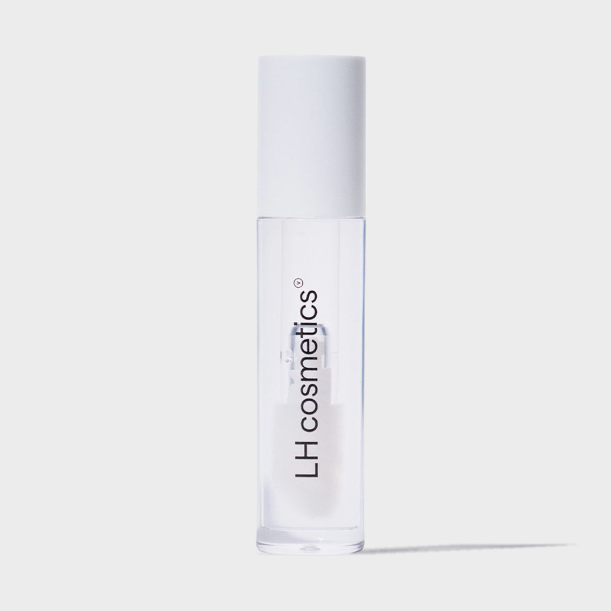 Eine transparente Tube Glazed Sweet von LH Cosmetics mit weißem Deckel und transparentem Inhalt vor weißem Hintergrund.