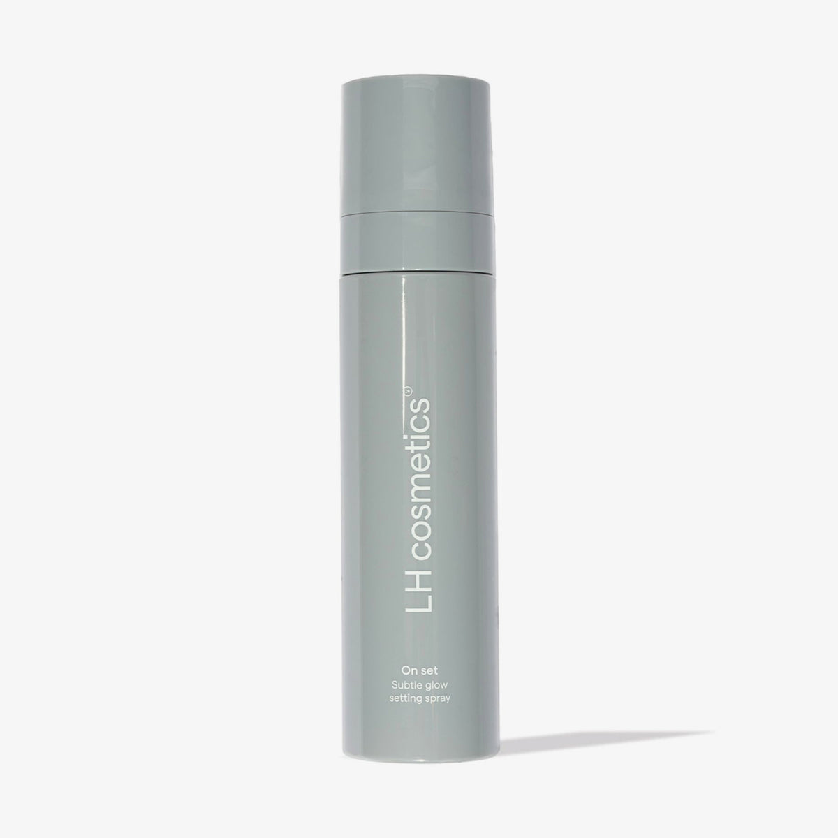 Eine graue Flasche „LH Cosmetics On Set – Subtle Glow Setting Spray“ wird vor einem weißen Hintergrund präsentiert.