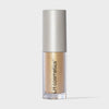 Transparente Tube Sparkl von LH Cosmetics mit weißer Kappe und gelb-gold schimmerndem Farbton namens Charm.