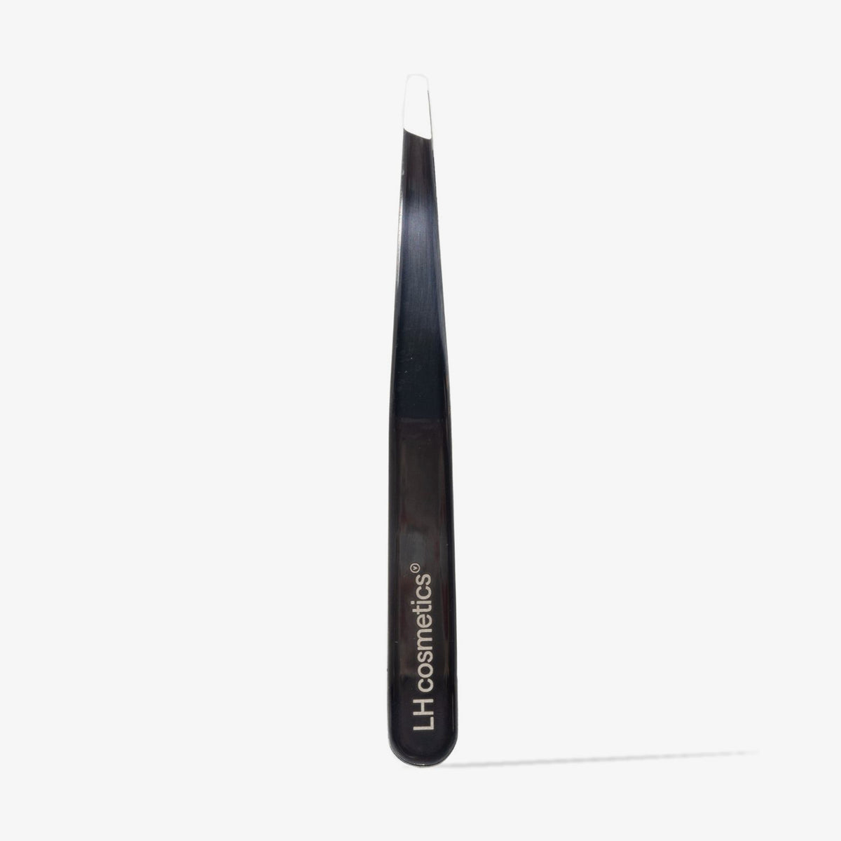 The Tweez von LH Cosmetics, eine schwarz-graue Pinzette mit abgeschrägter Spitze, steht aufrecht vor einem weißen Hintergrund.