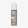 Beige Flasche Living Proof No Frizz Smooth Styling Spray mit weißem Deckel vor weißem Hintergrund.