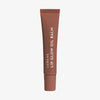 Eine braune Tube Lip Glow Oil Balm Blackcurrant mit weißem Text vor weißem Hintergrund
