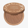 Offene Dose Lumene NATURAL GLOW Bronzer in der Farbe Arctic Sun mit geometrischem Design auf warmbraunem Puder und Deckel.