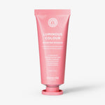 Eine rosafarbene Tube der maria nila Booster Masque Luminous Colour steht aufrecht vor einem weißen Hintergrund.