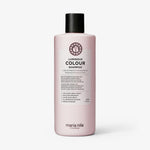 Rosafarbene Flasche maria nila Luminous Colour Shampoo mit einer schwarzen Kappe ist vor einem weißen Hintergrund abgebildet.