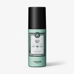 Eine grüne Flasche maria nila Salty Mist mit schwarzem Deckel ist auf weißem Hintergrund abgebildet.