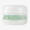 Weiße Dose der Mario Badescu Drying Cream mit grünem Schriftzug auf weißem Hintergrund.