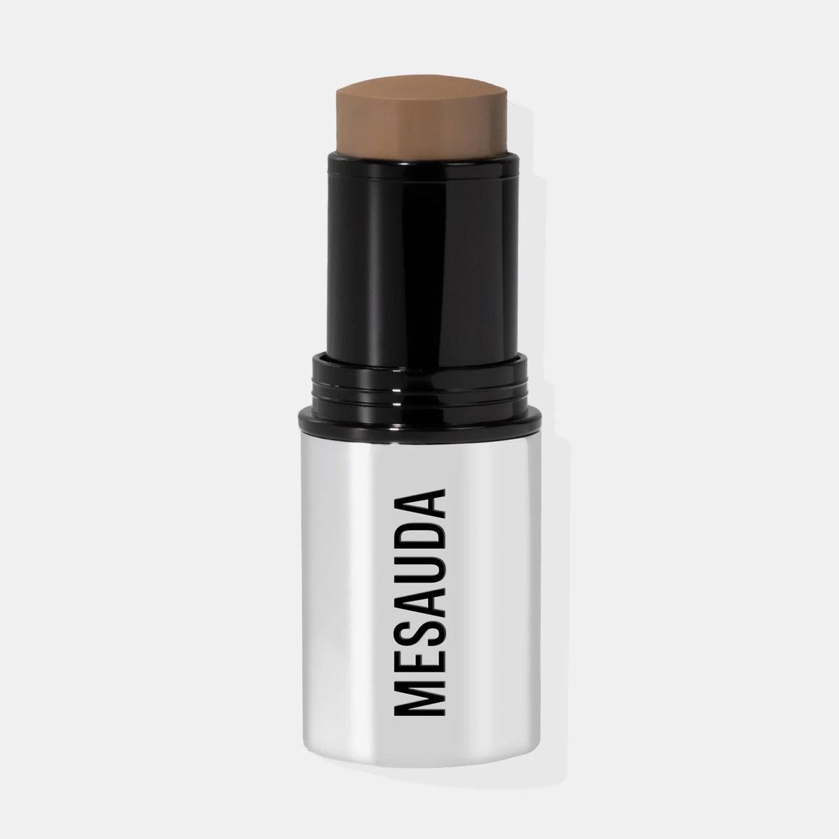 Ein silber-schwarzer Make-up-Stick mit dem leicht herausgedrehten The Mood Contrast 102 Medium von Mesauda vor weißem Hintergrund.