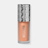 Die Flasche Flush of Light Blossom Shine von Mesauda mit silbergemustertem Deckel und pfirsichfarbenem Inhalt.