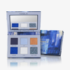Die Cutie Palette - Midnight - von Nabla mit sechs Lidschattentönen und einem Spiegel wird geöffnet neben ihrer blauen Verpackungsbox präsentiert.