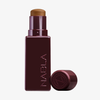 Art Of Skin Foundation Stick von NABLA Cosmetics, abgebildet in kastanienbraun mit abgenommener Kappe und neben der Tube platziert, auf weißem Hintergrund.