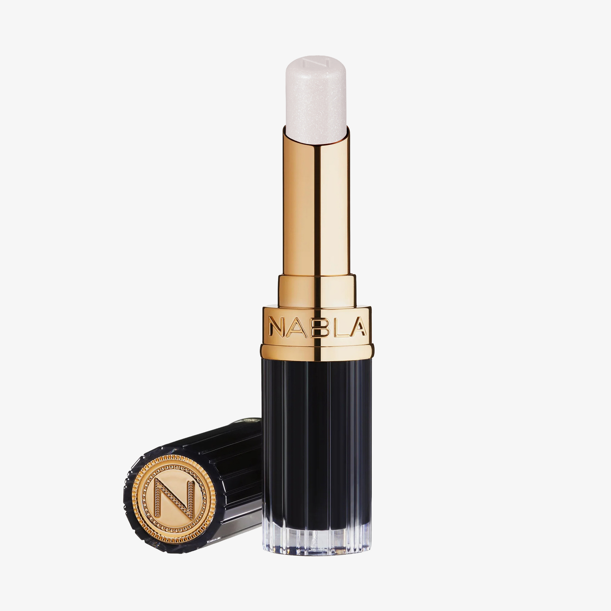 Eine Tube NABLA Cosmetics Beyond Jelly Lipstick Perlati Crystal Dream in einem gold-schwarzen Etui, Kappe daneben.