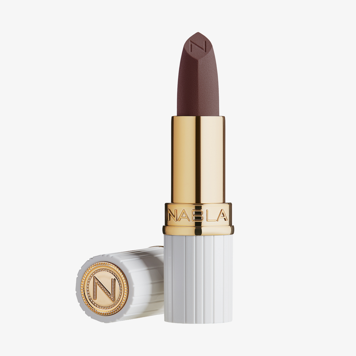 Matte Pleasure Lipstick von NABLA Cosmetics in brauner, goldener und weißer Tube mit abgesetzter Kappe neben der Basis auf weißem Hintergrund.