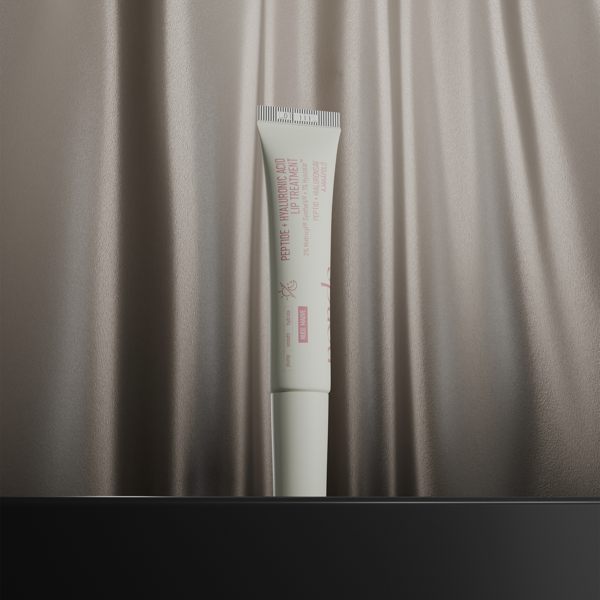 Eine Tube der NERDS. Peptide + Hyaluronic Acid Lip Treatment steht aufrecht vor einem seidig-beigen Stoffhintergrund.