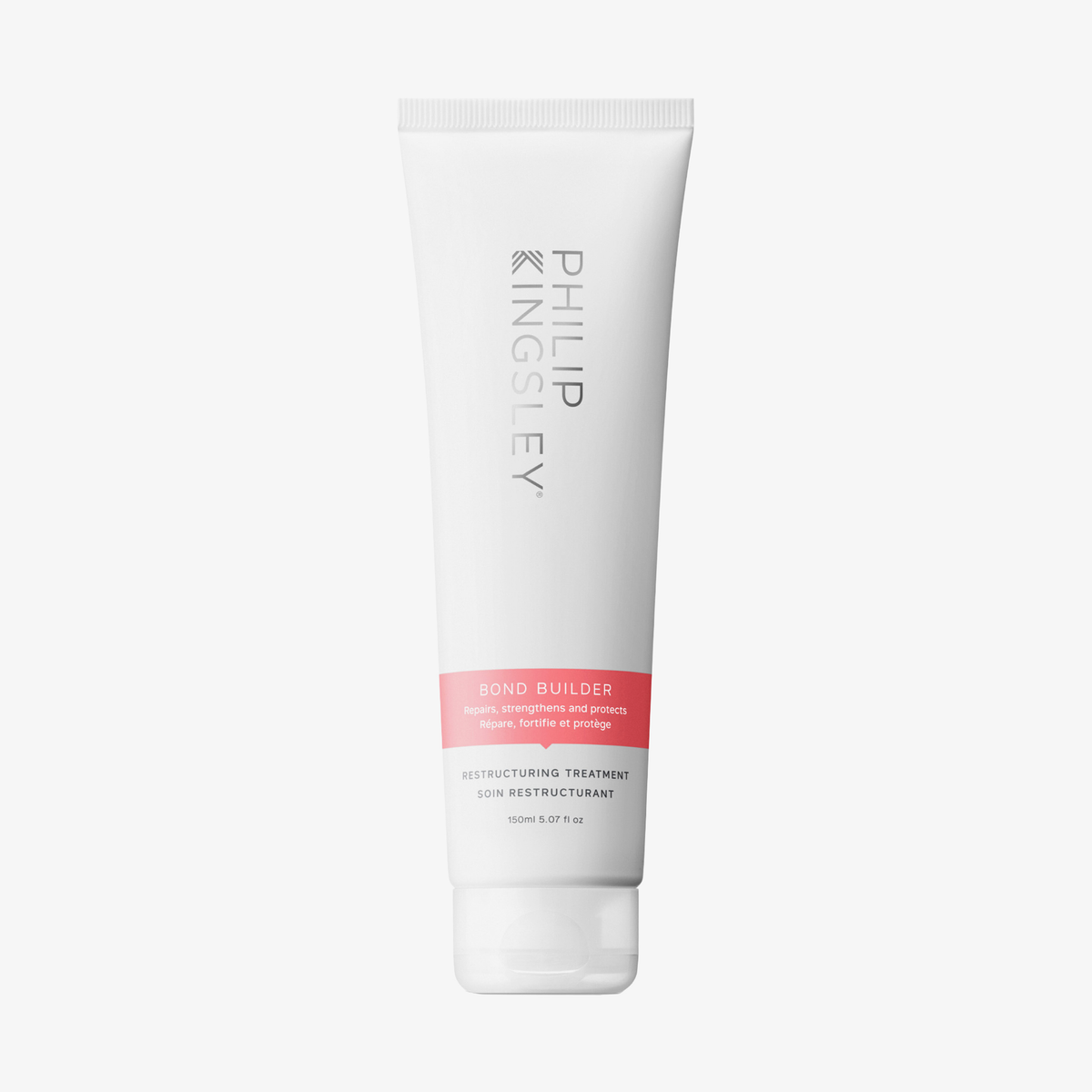 Eine weiße Tube „Philip Kingsley Bond Builder Restructuring Treatment“ mit einem rosa-grauen Etikett auf weißem Hintergrund.