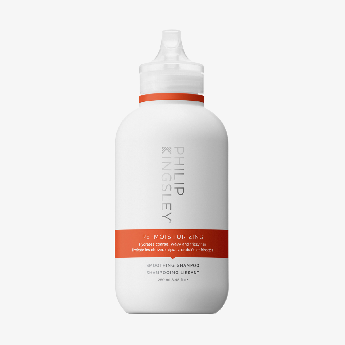Weiße 250-ml-Flasche „Philip Kingsley Re-Moisturizing Shampoo“ mit orangefarbenem Etikett und spitz zulaufendem Verschluss.