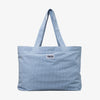 Die PURISH Beach Bag ist eine hellblaue Stofftasche mit „PURISH“ Patch auf der Vorderseite und zwei langen Schultergurten.