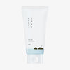 Eine weiße Tube 1025 Dokdo Cleanser, zeigt minimalistische Berg- und Wasserillustrationen auf der Verpackung.