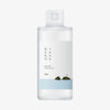 ROUND LAB 1025 Dokdo Toner: durchsichtige Flasche mit minimalistischem Etikett, koreanischem Text und einer Abbildung von zwei Felsen im Meer.