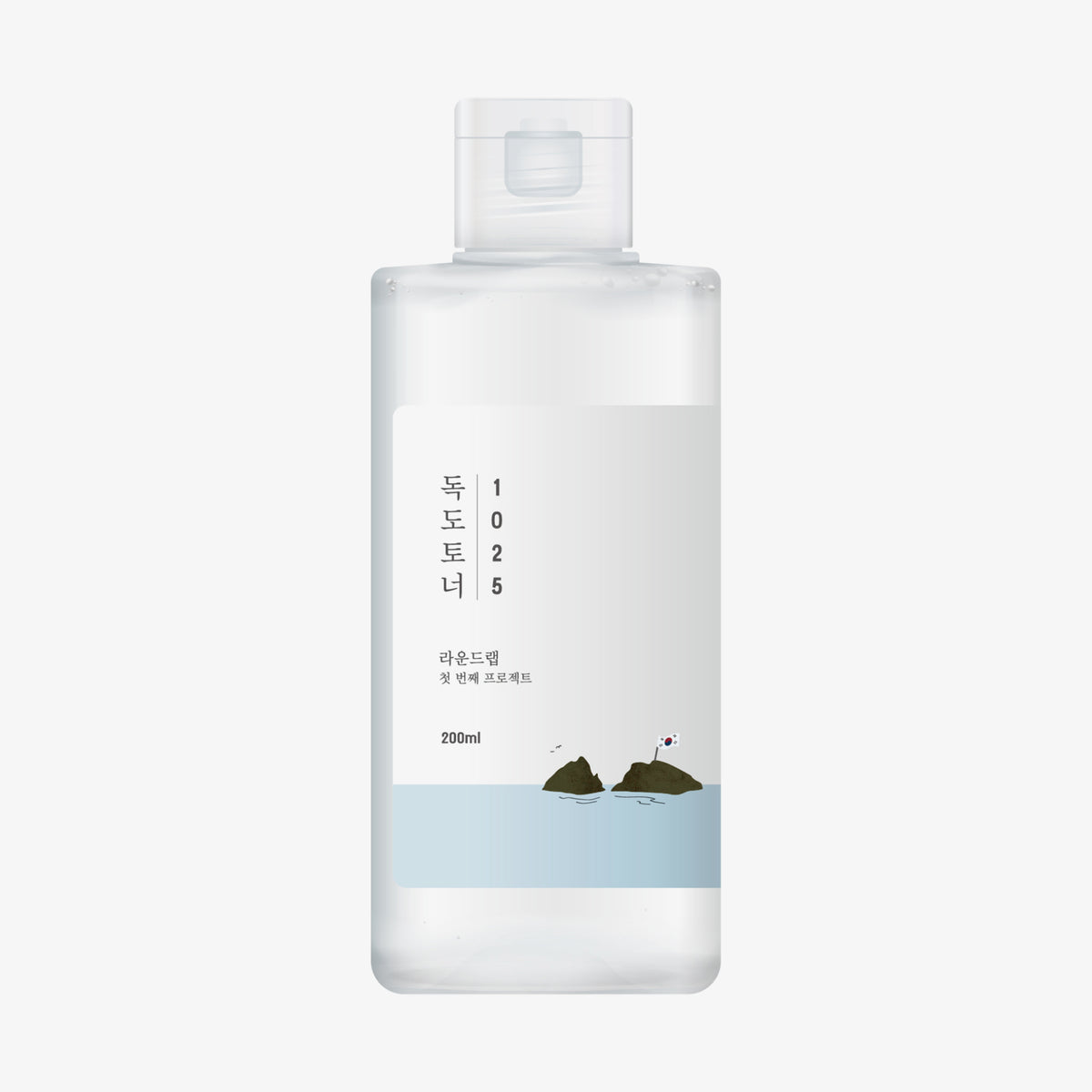ROUND LAB 1025 Dokdo Toner: durchsichtige Flasche mit minimalistischem Etikett, koreanischem Text und einer Abbildung von zwei Felsen im Meer.