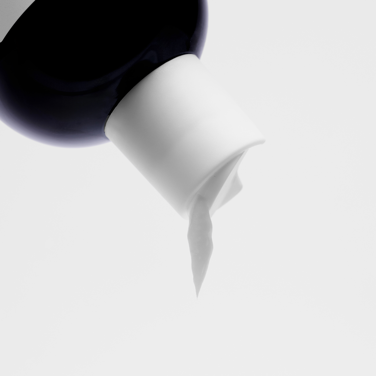 Eine schwarze Flasche Scandinavian Biolabs Bio-Pilixin® Conditioner+ Women mit weißem Flip-Top-Verschluss spendet einen weißen Conditioner vor einem schlichten Hintergrund.