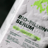 Nahaufnahme einer schaumigen weißen Bio-Pilixin® Serum+ Women Verpackung von Scandinavian Biolabs, die neongrüne Akzente aufweist.