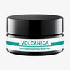 Ein schwarzes Gefäß mit einem grün-weißen Design und der Aufschrift „Volcanica Calming and Purifying Facial Mask“.