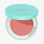 Eine geöffnete, türkisfarbene SWEED Air Blush Cream-Dose zeigt das darin enthaltene rosa Rouge, auf dem Deckel ist das SWEED-Logo zu sehen.