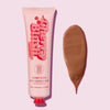 Cherry Blush Rapid Warming Balm in einer rosa Tube neben einem Abstrich auf einem hellrosa Hintergrund.