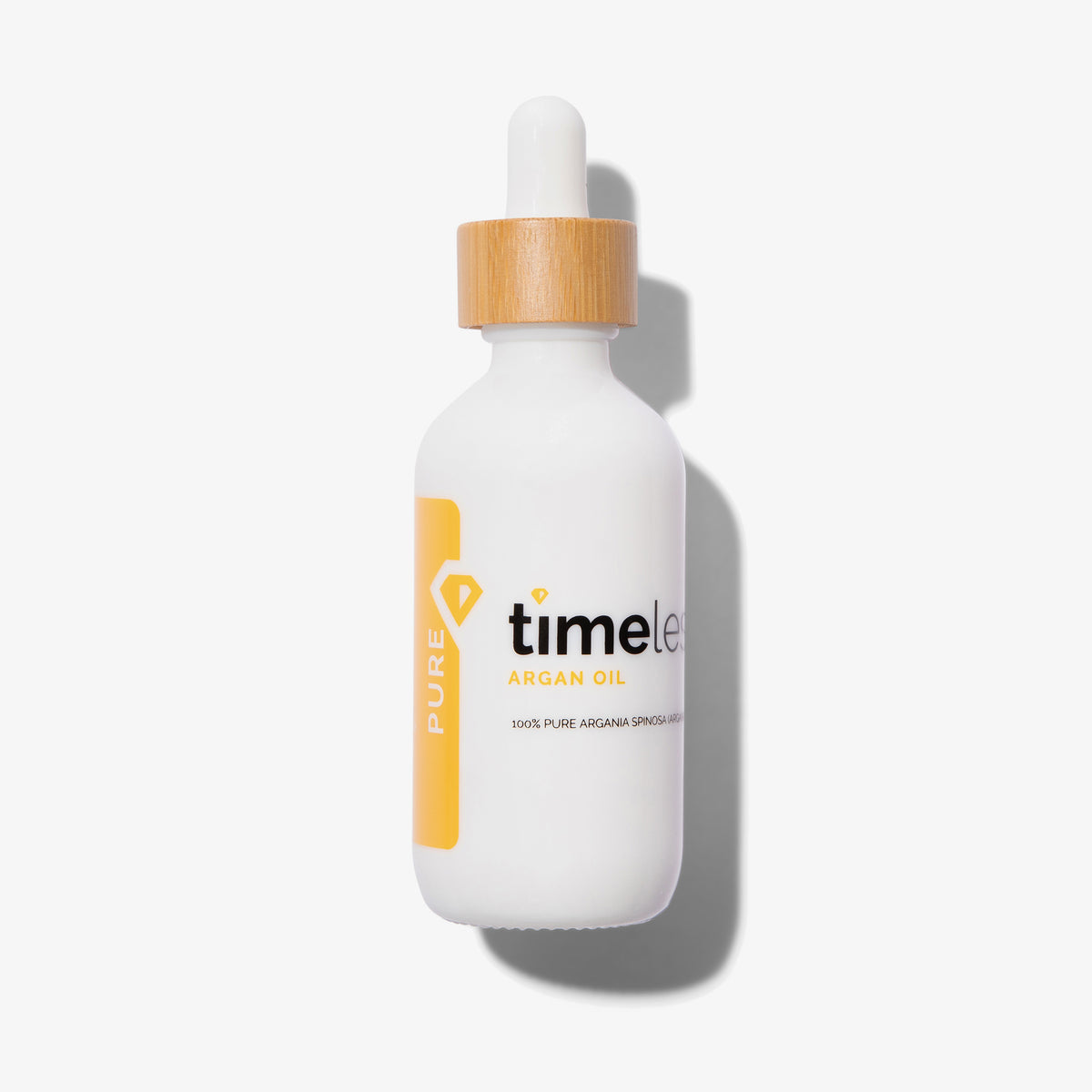 Weiße Flasche 100 % reines Arganöl von Timeless Skincare mit Holzdeckel und Pipette vor weißem Hintergrund. 60 ml.