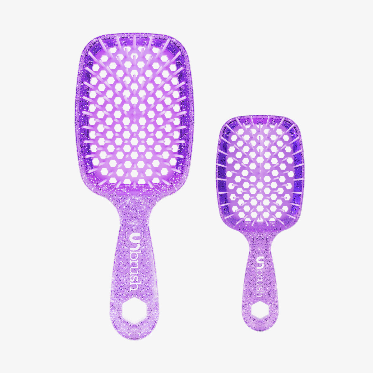 Das UNbrush Glitter Duo Set Amethyst Lavender enthält zwei lilafarbene, glitzernde Haarbürsten, eine große und eine kleine, jeweils mit dem UNbrush-Logo auf dem Griff.