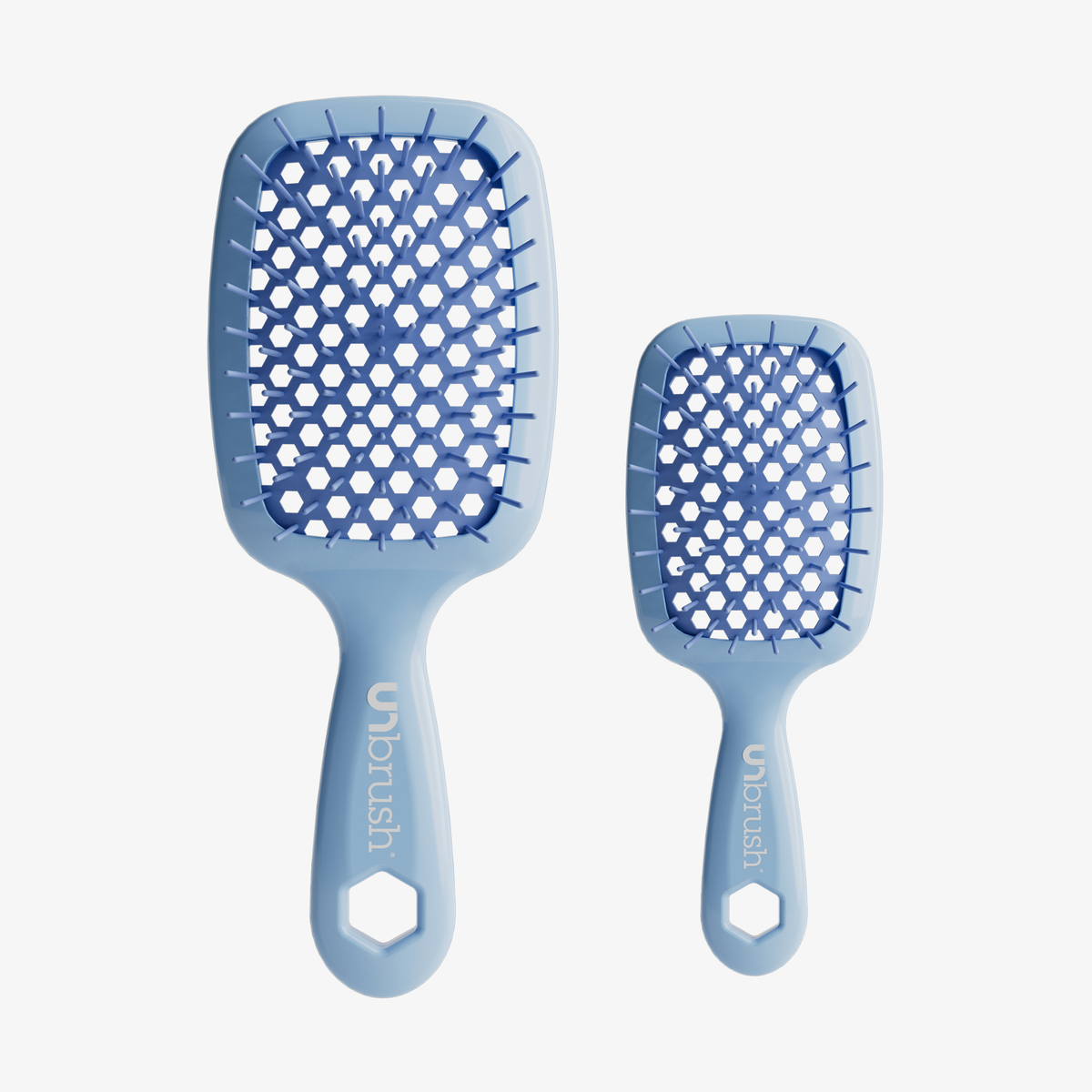 Das UNbrush Pastell-Duo-Set besteht aus zwei hellblauen Paddle-Haarbürsten, einer großen und einer kleinen, beide mit wabenförmiger Rückseite, auf weißem Hintergrund.