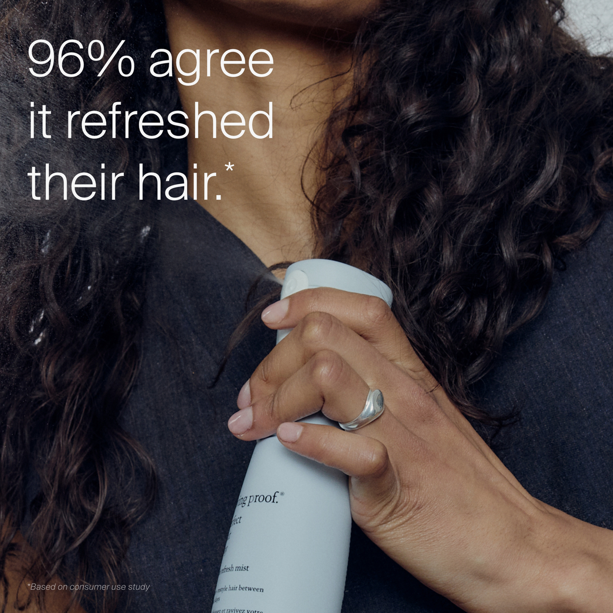 Frau mit lockigem Haar halten Living Proof Perfect Hair Day Style Refresh Mist; 96 % stimmen zu, dass es ihr Haar erfrischt hat.