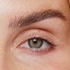 Nahaufnahme eines menschlichen Auges mit langen, natürlichen Wimpern, die durch den XLASH Lash Booster betont wurden, und gepflegten Augenbrauen.