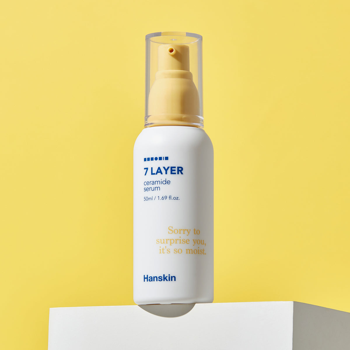 Eine Flasche Seven Layer Ceramide Serum mit Pumpe vor einem einfarbig gelben Hintergrund.
