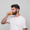 Ein Mann mit dunklen Haaren und einem Bart trägt ein weißes T-Shirt und trinkt Bio-Silacumin von Scandinavian Biolabs.