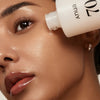 Eine Nahaufnahme einer Frau, die Rice 70 Glow Milky Toner auf ihre strahlende, taufrische Haut aufträgt.