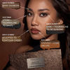 Eine Frau hält die Danessa Myricks Beauty Groundwork Palette - Defining Neutrals in der Hand, deren Etiketten zeigen, wie die einzelnen Farbtöne auf ihr Gesicht aufgetragen werden.