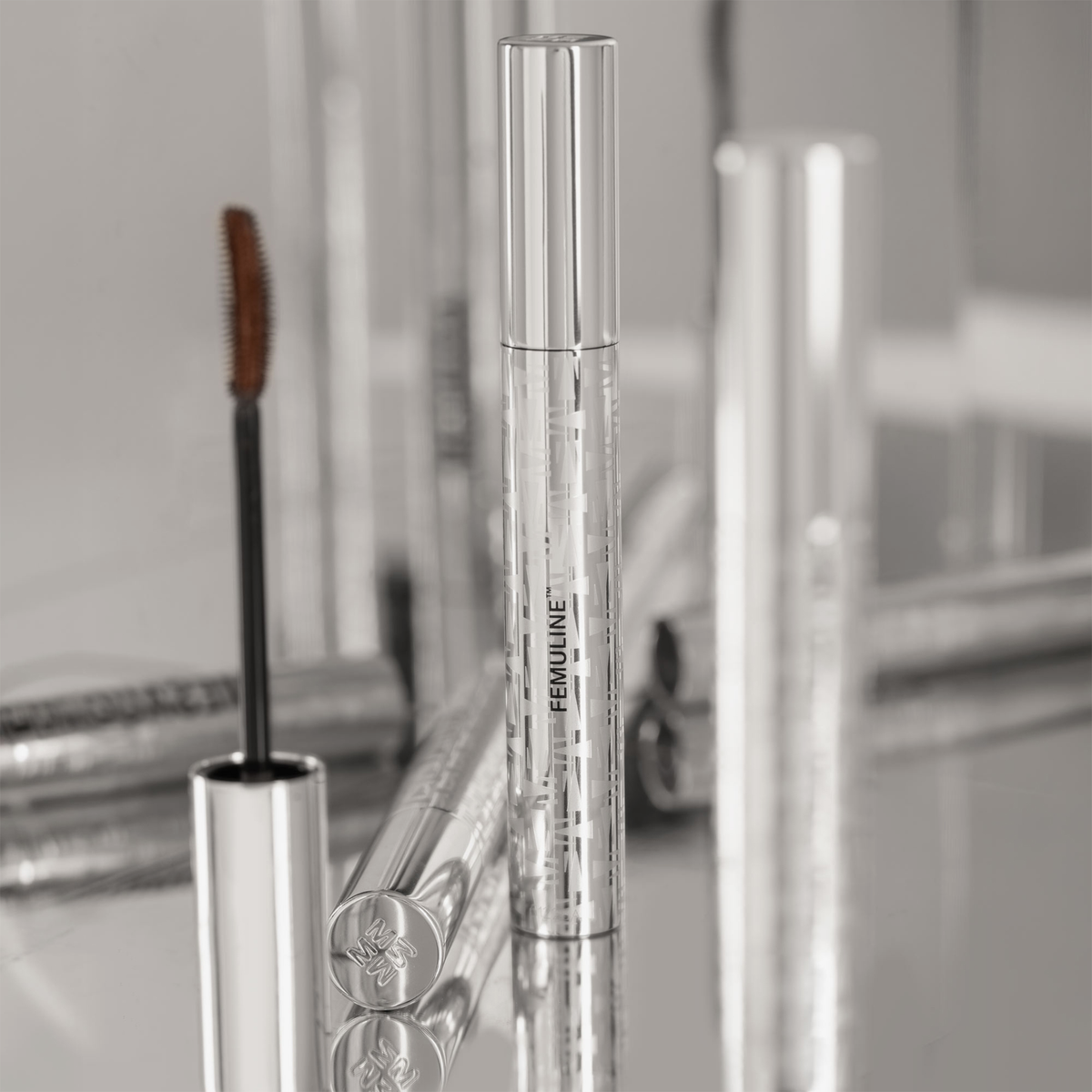 Eine Mascara-Tube SPACE GAZE CHRISTMAS KIT von Mesauda Beauty in einem silbermetallischen Gehäuse, deren Applikator herausgezogen ist.