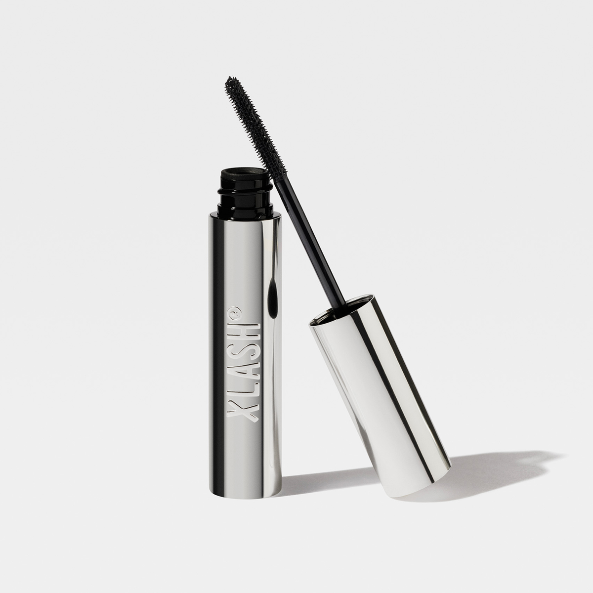 Silver XLASH Lash Booster-Mascara-Tube mit herausgezogenem Applikatorpinsel.