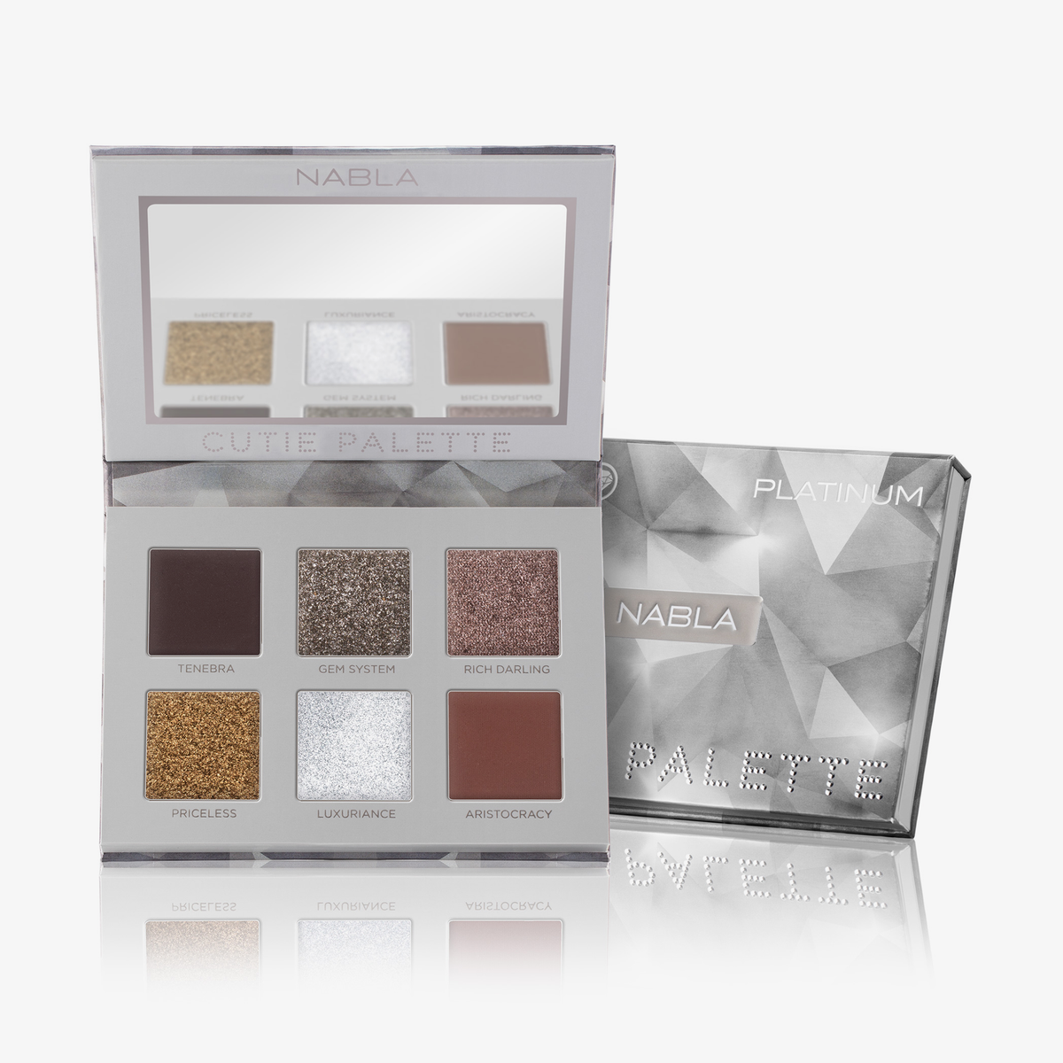 Geöffnete NABLA „Cutie Palette Platinum“ mit sechs kühlen Lidschattentönen und Spiegel, daneben geschlossene silberne Verpackung mit Facettendesign.