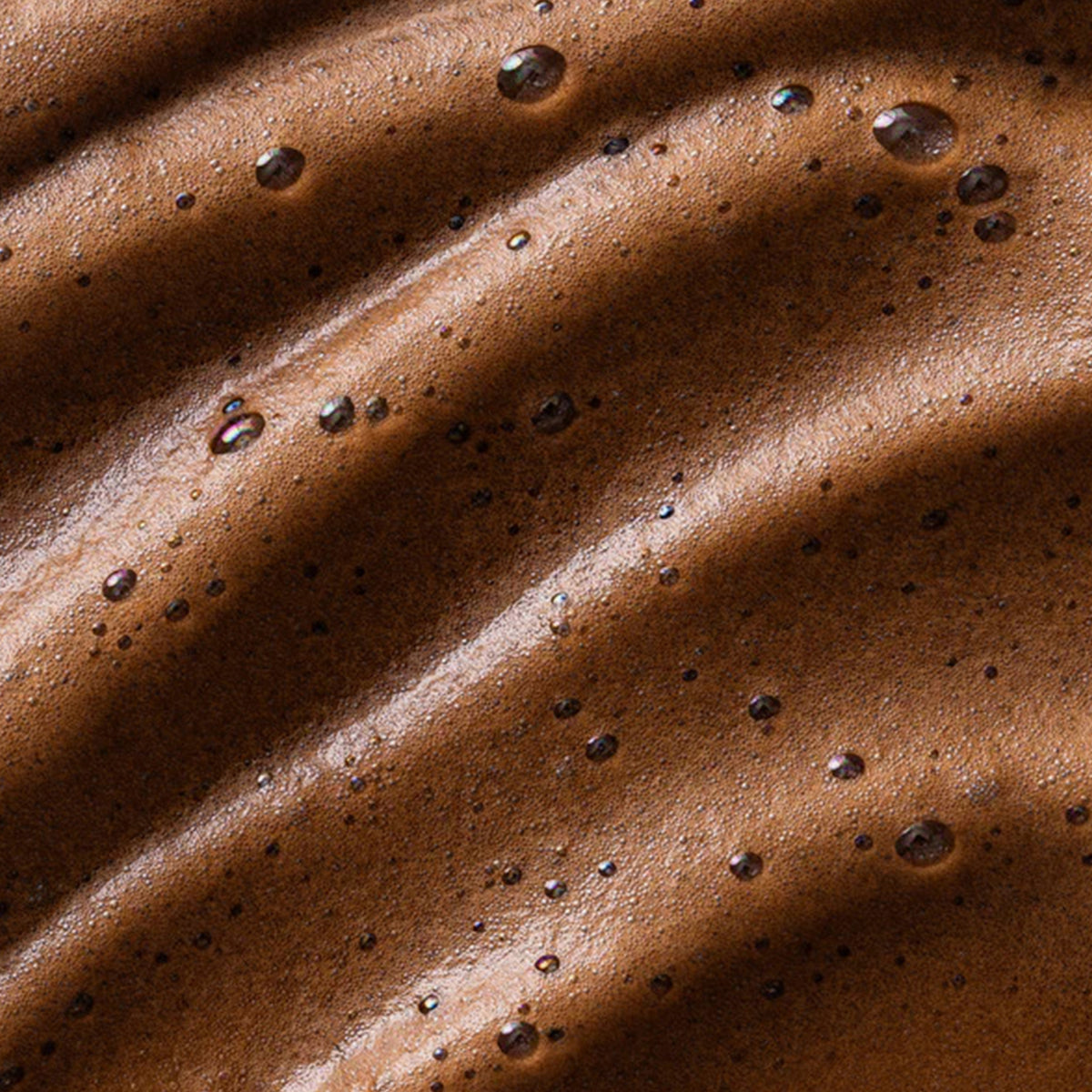 Nahaufnahme des braunen Bronzing Instant Tan Mousse mit schaumig strukturierter Oberfläche
