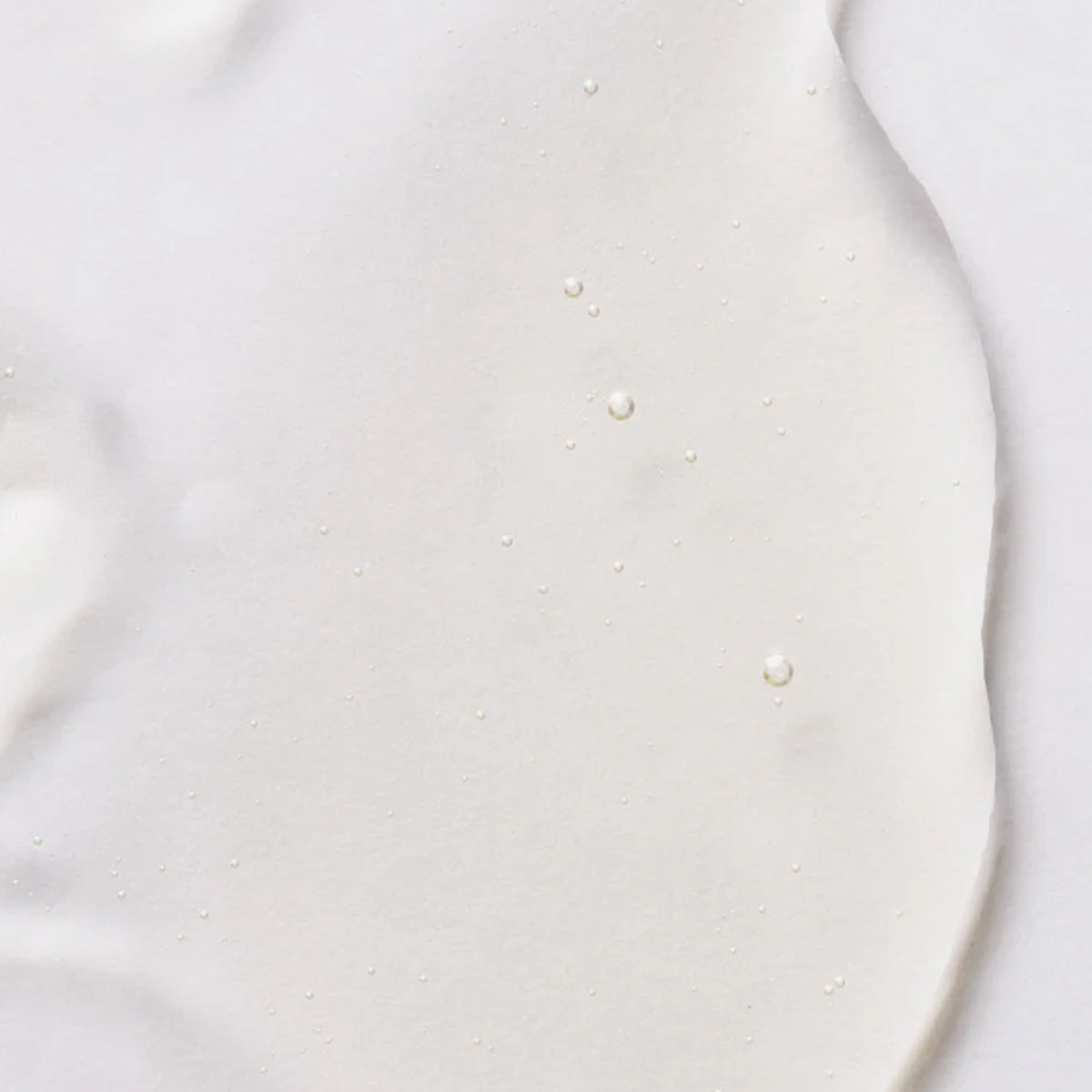 Nahansicht des dursichtigen Watermelon Sunscreen Oil SPF50 von Bali Body auf weißer Oberfläche.
