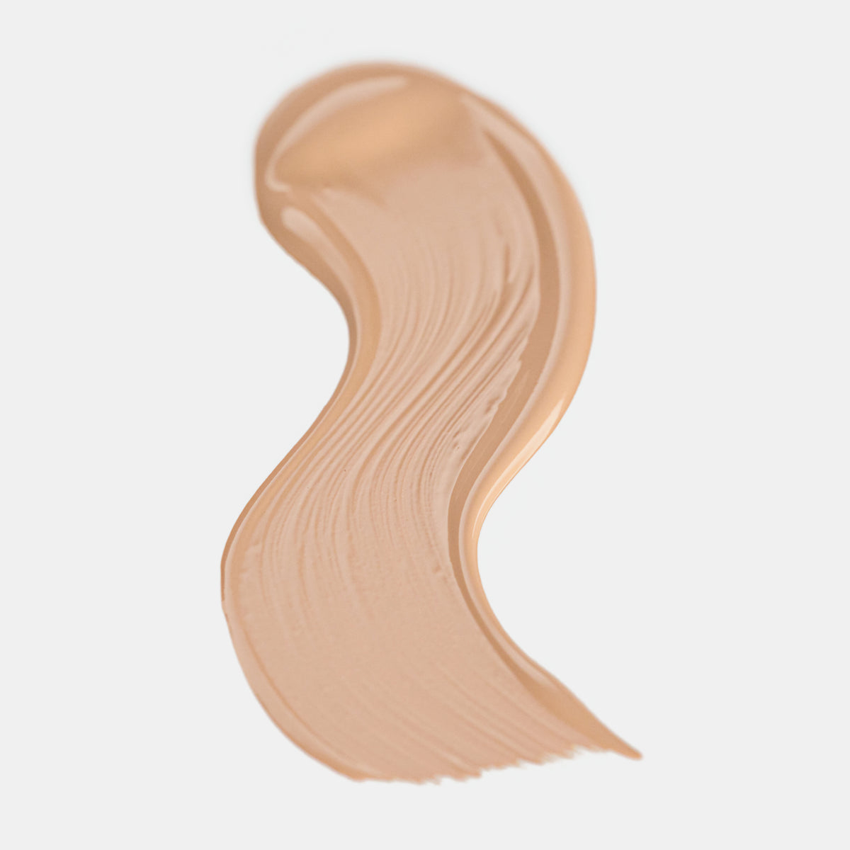 Cremiger Farbstreifen des Catrice Instant Bright Serum Concealers in der Farbe 005W (warmes Beige) auf heller Oberfläche.