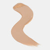 Cremiger Farbstreifen des Catrice Instant Bright Serum Concealers in der Farbe 020W (warmes Beige) auf heller Oberfläche.