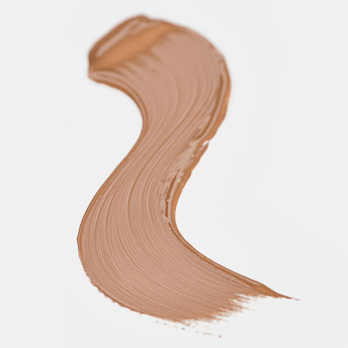 Cremiger Farbstreifen des Catrice Instant Bright Serum Concealers in der Farbe 046W (Warmes dunkles Beige) auf heller Oberfläche.