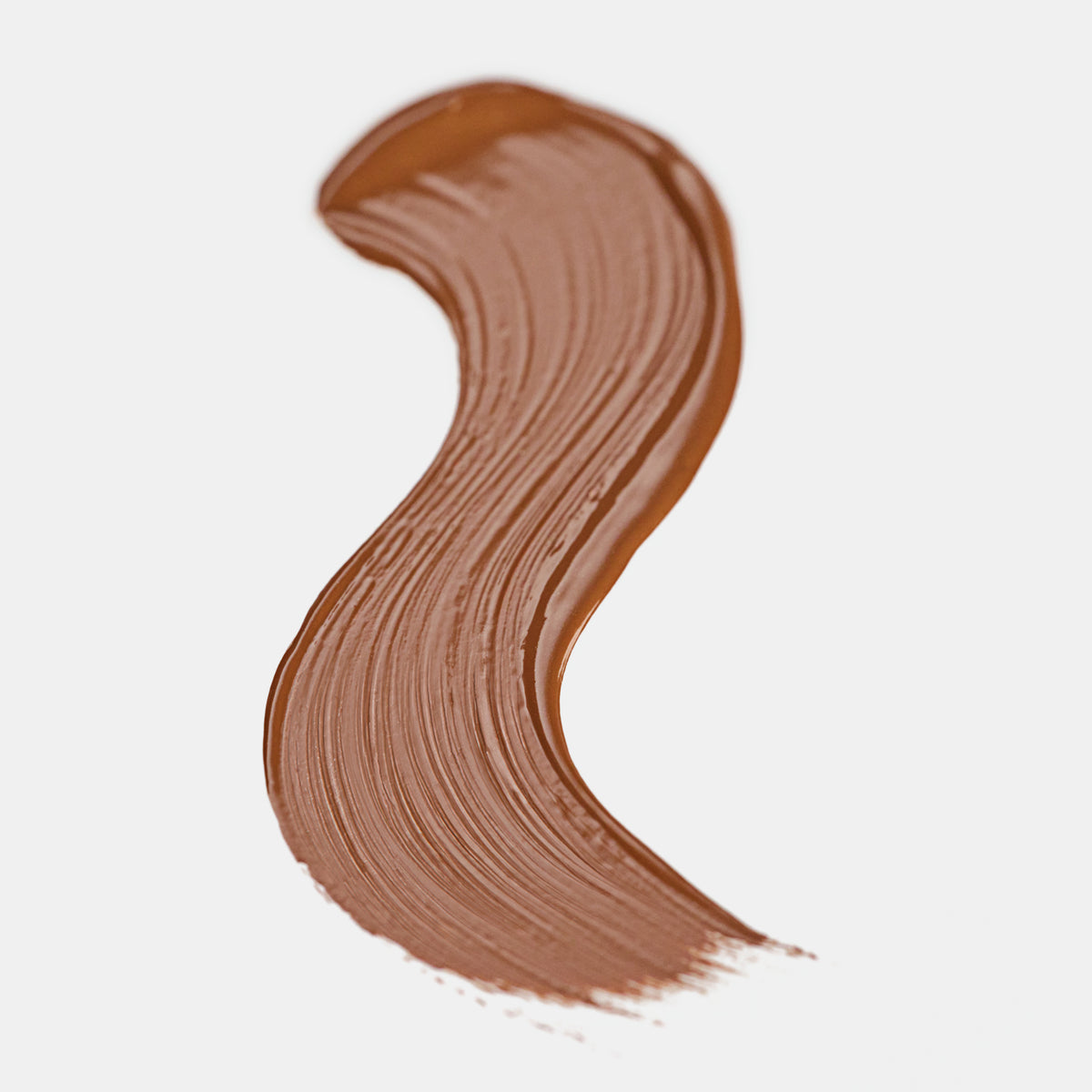 Cremiger Farbstreifen des Catrice Instant Bright Serum Concealers in der Farbe 090C (mittleres Braun) auf heller Oberfläche.