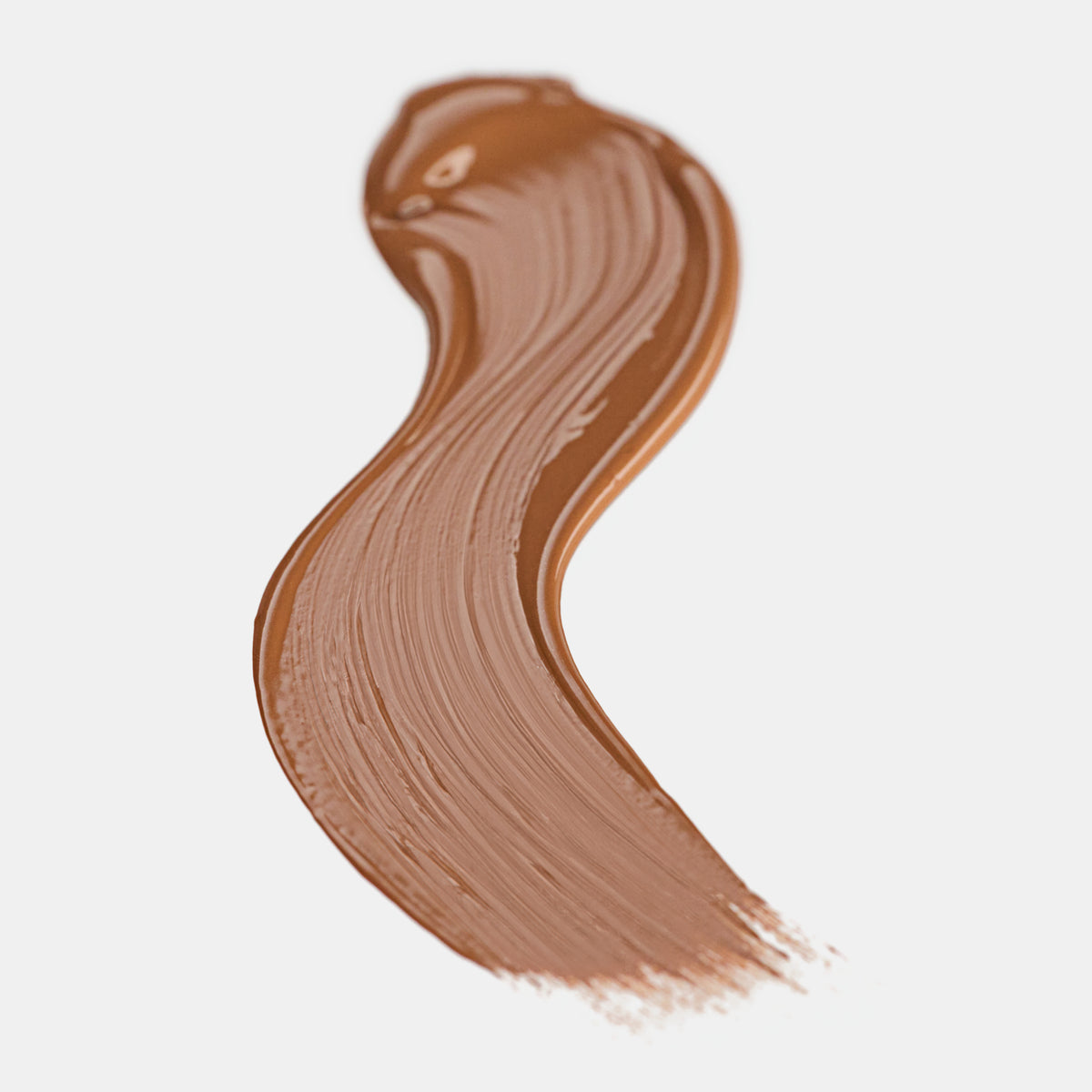 Cremiger Farbstreifen des Catrice Instant Bright Serum Concealers in der Farbe 092W (warmes Braun) auf heller Oberfläche.
