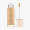 Eine geöffnete Flasche Soft Glam Filter Fluid 020 mit im Deckel integrierten Applikator vor weißem Hintergrund.