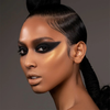 Frau mit glattem Haar, kräftigem schwarzem Winged Eyeshadow und goldenem Wangenknochen-Highlight mit Danessa Myricks Beauty Balm Contour.